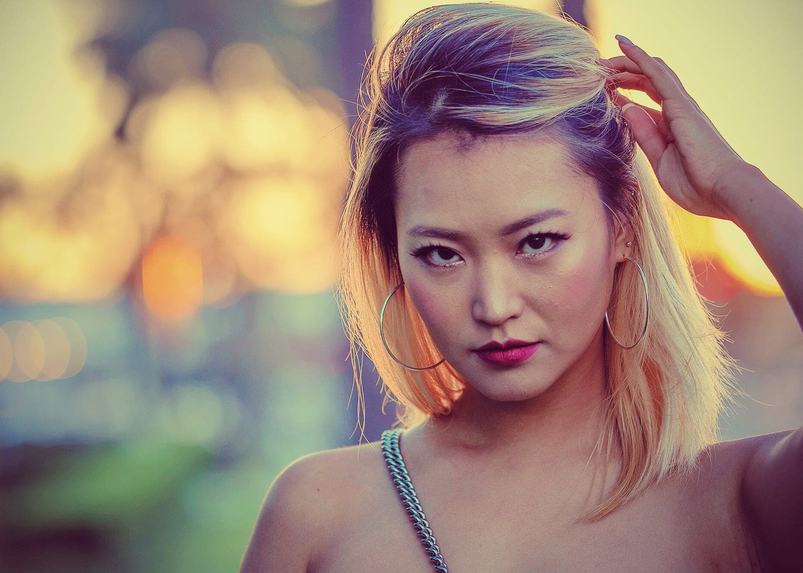 Beauty portrait commission by Henry David: dramatic coloured light, gold hoop earrings, direct gaze