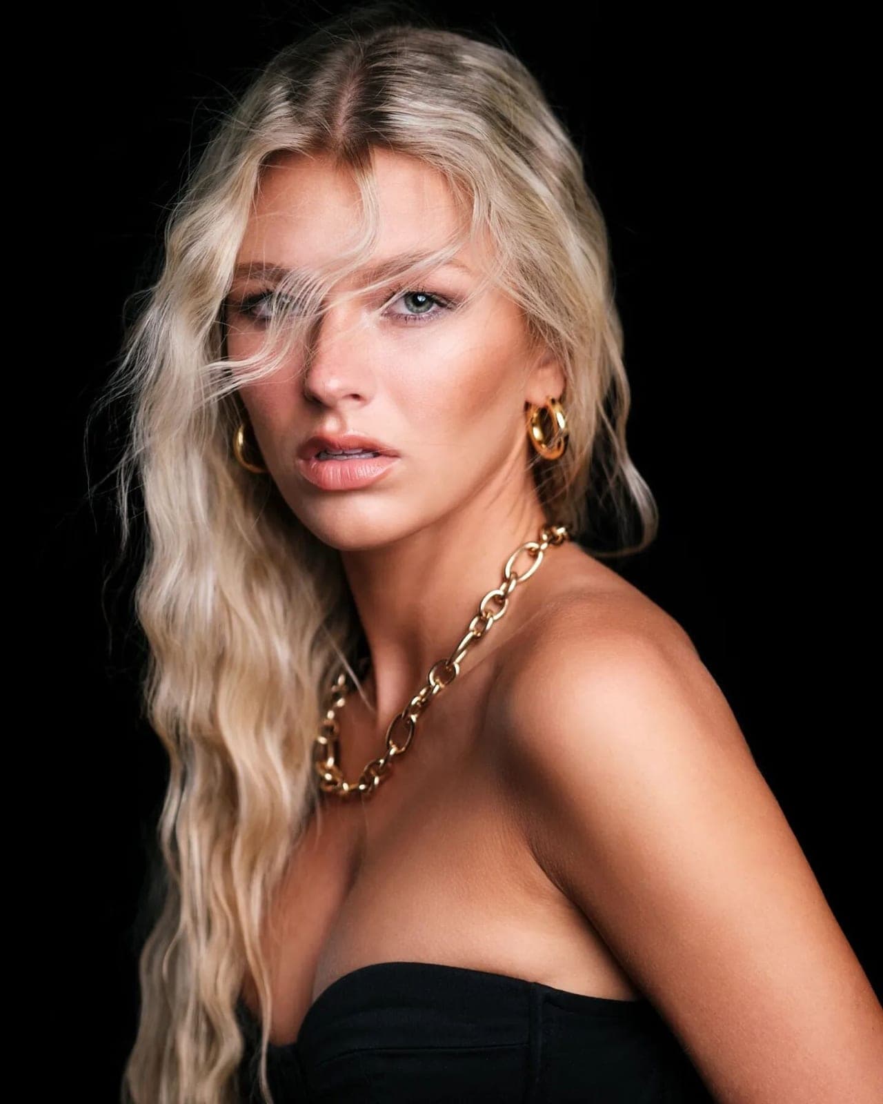 Studio portrait commission by Henry David: gold chain and bare shoulders against a dark ground