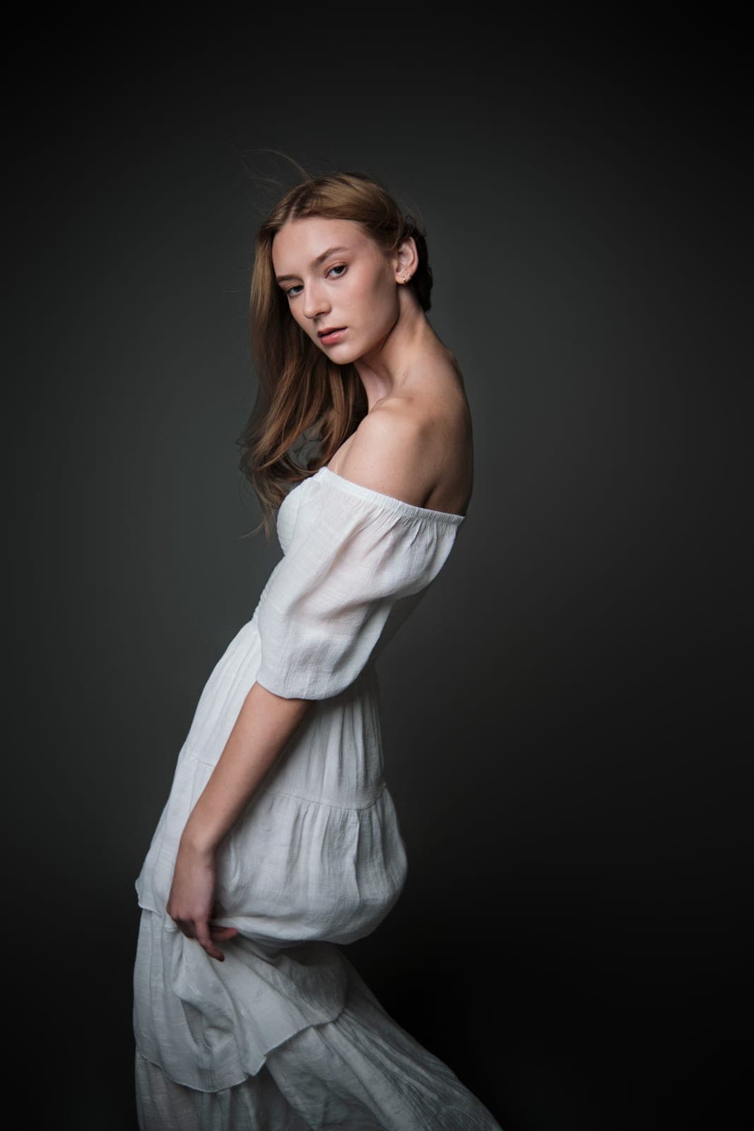 Portrait commission by Henry David: white off-shoulder dress against a dark ground