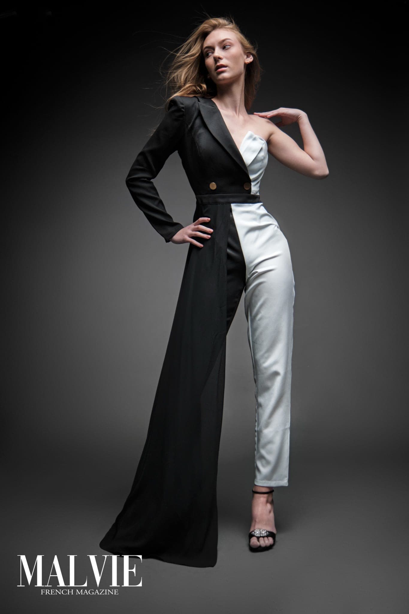 McKenna Vereeke full length in black and white tuxedo jumpsuit, hand on hip, flowing fabric studio editorial by Henry David